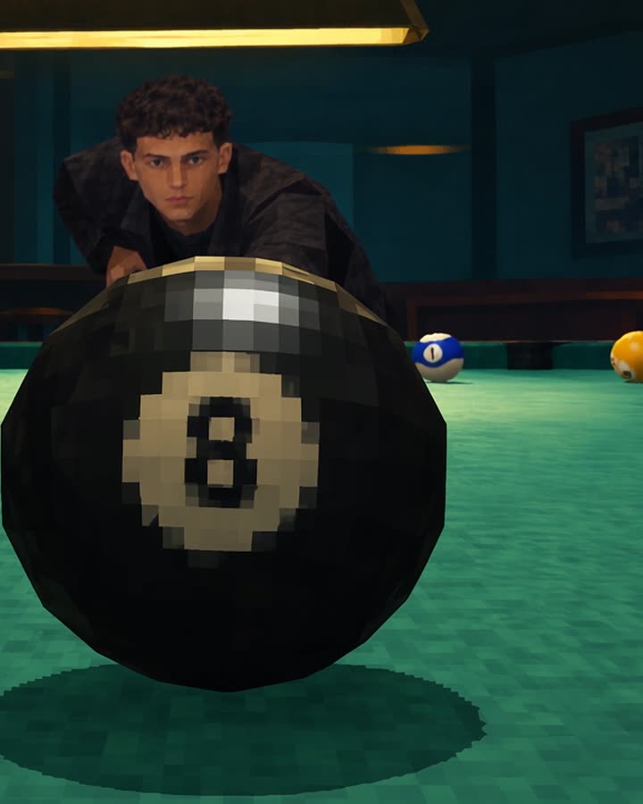 Italo leaning over a pool table to line up a shot, the 8 ball in the foreground